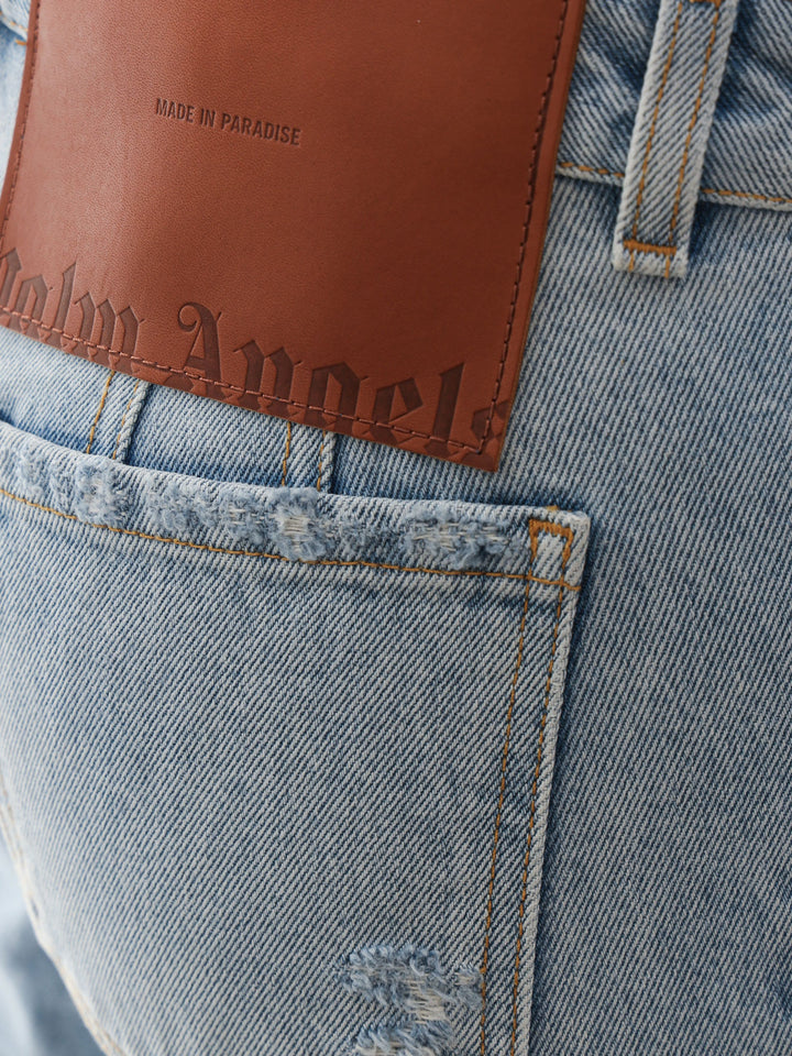 Jeans in cotone con patch logo posteriore in pelle